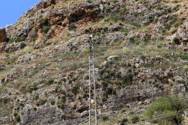 İsrail 'de mavi gökyüzüne karşı yalıtkan ve elektrik kablolarıyla metal destek direği 