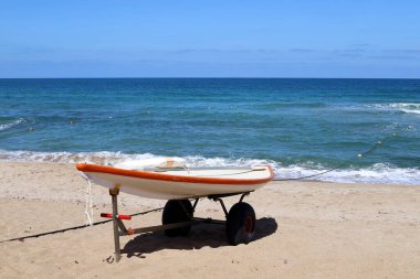 İsrail 'in kuzeyinde Akdeniz kıyısındaki kumlu bir sahilde cankurtaran botu. 