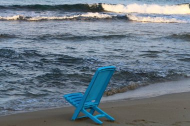Kuzey İsrail 'de Akdeniz kıyısındaki bir şehir plajında bir sandalye duruyor. 