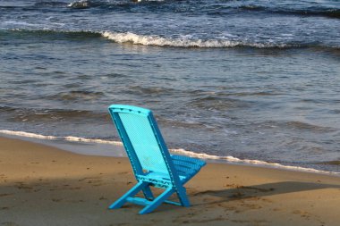 Kuzey İsrail 'de Akdeniz kıyısındaki bir şehir plajında bir sandalye duruyor. 