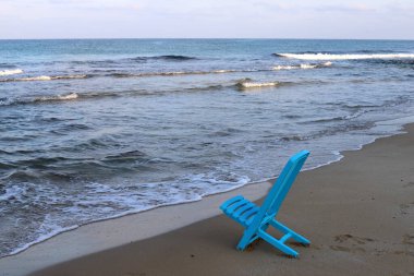 Kuzey İsrail 'de Akdeniz kıyısındaki bir şehir plajında bir sandalye duruyor. 