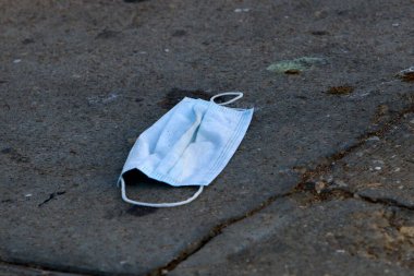 Eski ve kirli tıbbi maske İsrail 'in büyük bir şehrindeki bir şehir parkında yatıyor. 