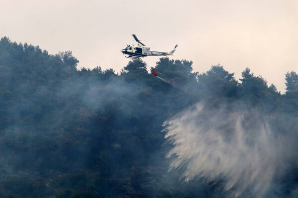 a United Nations helicopter extinguishes a fire on the Israel-Lebanon border 