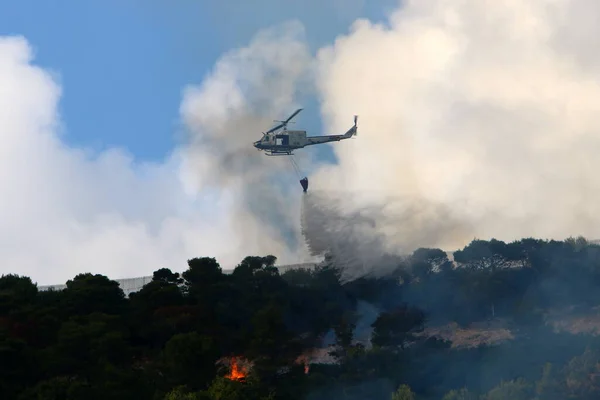 a United Nations helicopter extinguishes a fire on the Israel-Lebanon border