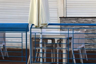 Covid-19 salgını sırasında kapalı olan, çalışmayan bir kafede sandalye ve masalar. 