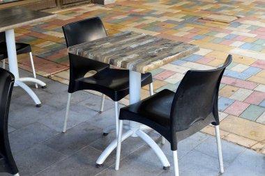 Covid-19 salgını sırasında kapalı olan, çalışmayan bir kafede sandalye ve masalar. 