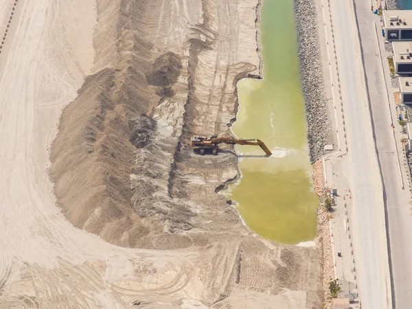 Excavator machinery at construction site, desert in background. Accelerated video view.