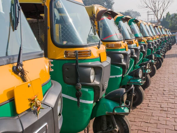 Yellow and green auto rickshaws in Indiya.