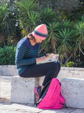 Haifa, İsrail, 19 Kasım 2016: Haifa, İsrail için bir kitap okuma ve açık havada oturma genç kız