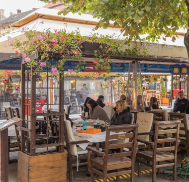 Sibiu, Romanya, 07 Ekim 2017: Ziyaretçi sokak bir kafede yağmurlu günde Sibiu Romanya şehirde oturuyor