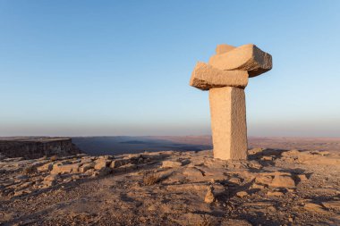Birkaç kesilerek taşlar üzerinde başka bir ayakta İsrail Judean desert arka planı dağların uçurumdaki günbatımında yerleştirilir