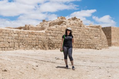 Genç kadın Nabataean city Avdat, şehir kale duvarlarının fonunda poz bulunan İsrail Judean desert tütsü yolu üzerindeki.
