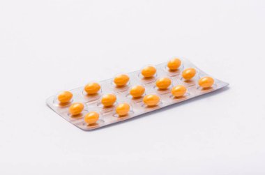 Beyaz bir arka plan üzerinde hapları yalan bir komple kapalı paket ile sarı oval şeklinde