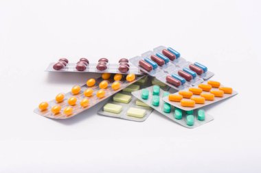 Birkaç mühürlü paketleri tablet ile tam ve farklı renkler ve farklı şekiller hapları beyaz bir arka plan üzerinde yalan söylüyorsun