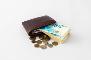 Kahverengi deri cüzdan ve banknot yığını ve birkaç sikkeleri üzerinde beyaz arka plan izole Yeni İsrail Şekeli