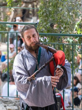 Jerusalem, Israel, September 29, 2018 : Participant of the festival in the traditional medieval dress plays music on the bagpipes at the annual festival `Jerusalem Knights`