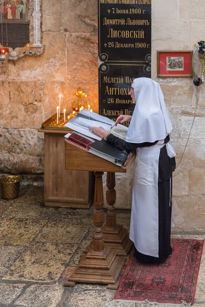 Jerusalem, Israel, November 17, 2018 : Nun reading a prayer in the lower prayer room in Alexander Nevsky church in Jerusalem, Israel