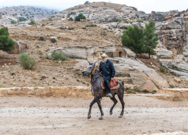 Wadi Musa, Ürdün, 06 Aralık 2018: Bedevi önde gelen Petra - Ürdün Wadi Musa şehirde Nabatean krallığının başkenti yol boyunca bir Arap atı at binme