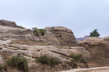 Rock Petra - Ürdün Wadi Musa şehirde Nabatean krallığının başkenti önde gelen road yakınındaki mağarada