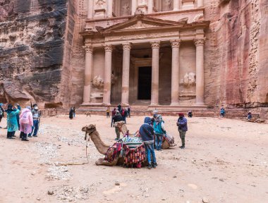 Wadi Musa, Ürdün, 06 Aralık 2018: Deve yerde yatan ve dinlenme ve Al-Khazneh Petra içinde önünde kare Wadi Musa city Ürdün yakınındaki turist bekliyor