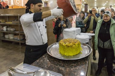 Majesteleri, Jordan, 05 Aralık 2018: Aşçı pan kaldırıldı ve çanak - Maklube - tepside yol kenarına yerleştirilen bir dükkanda - Restoran Kerak'a city Ürdün yakınındaki Şehirlerarası karayolu üzerinde yaptı