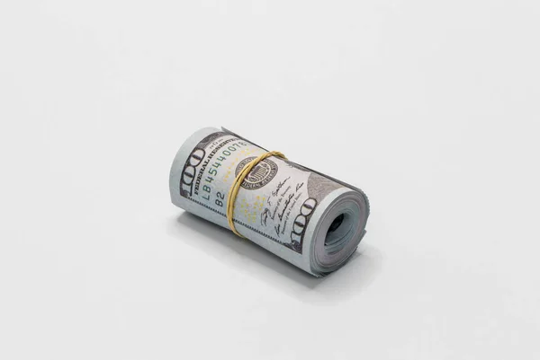 一堆面值100美元纸币的美元卷在一起 并与一个简单的橡皮筋在白色背景上被隔离在一起 — 图库照片