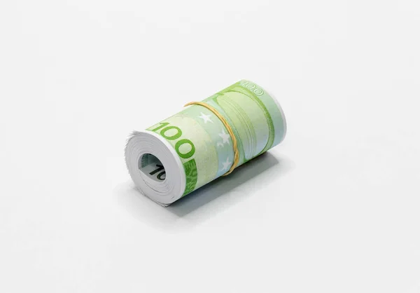 一堆欧洲欧元面值的100欧元纸币卷起 并与一个简单的橡皮筋一起固定在白色的背景上 — 图库照片