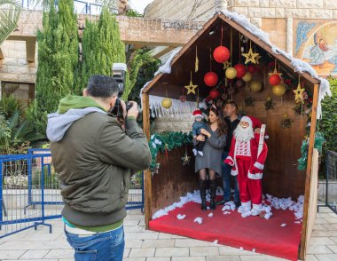 Nazareth, İsrail, 20 Aralık 2018: Bir fotoğrafçı Noel Baba şehirde Nazareth, İsrail ile genç bir aile fotoğrafı alır