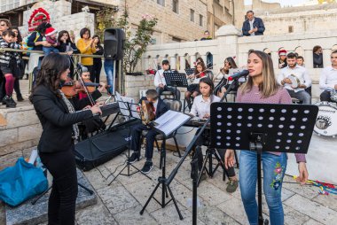 Nazareth, İsrail, 20 Aralık 2018: Bir grup genç sanatçının gerçekleştirmek Noel şarkıları İsrail şehir Nasıralı şehirde Noel ağacı yakınındaki meydanda