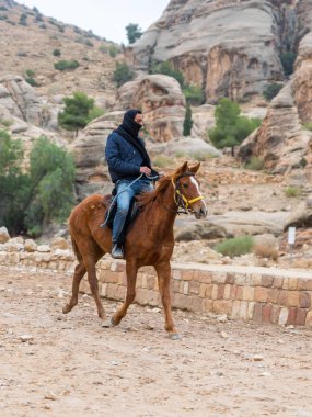 Wadi Musa, Ürdün, 06 Aralık 2018: Bedevi önde gelen Petra - Ürdün Wadi Musa şehirde Nabatean krallığının başkenti yol boyunca bir Arap atı at binme