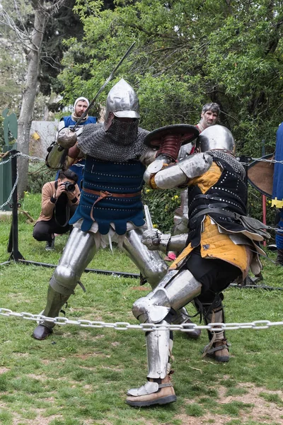 Два рыцаря со щитами и мечами сражаются на ринге на празднике Пурим с королем Артуром в Иерусалиме, Израиль — стоковое фото
