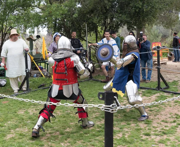 Dois cavaleiros com escudos e espadas lutam no ringue no festival Purim com o rei Artur na cidade de Jerusalém, Israel — Fotografia de Stock