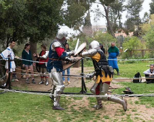 Two knights with shields and swords fight in the ring at the Purim festival with King Arthur in Jerusalem city, Israel — Stock Photo, Image