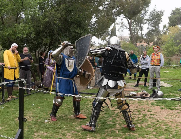 在以色列耶路撒冷的普林国王节上, 两个带着盾牌和剑的骑士在拳击场上战斗 — 图库照片