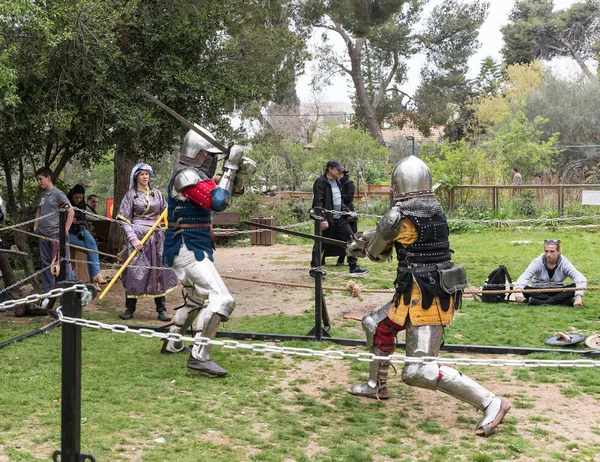 Two knights with swords fight in the ring at the Purim festival with King Arthur in Jerusalem city, Israel — Stock Photo, Image