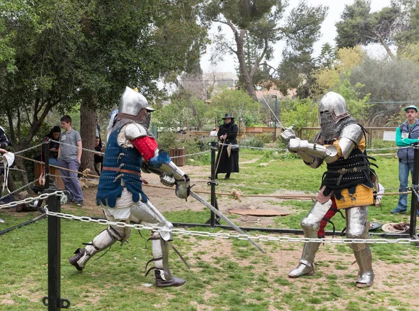 Two knights with swords fight in the ring at the Purim festival with King Arthur in Jerusalem city, Israel — Stock Photo, Image