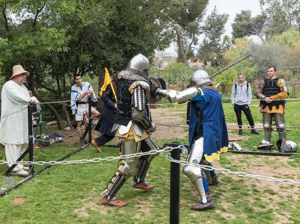 Two knights with shields and swords fight in the ring at the Purim festival with King Arthur in Jerusalem city, Israel — Stock Photo, Image