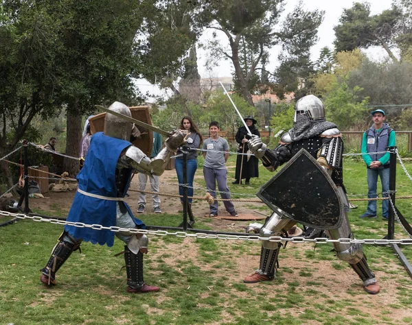 Dois cavaleiros com escudos e espadas lutam no ringue no festival Purim com o rei Artur na cidade de Jerusalém, Israel — Fotografia de Stock