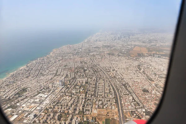 A Tel Aviv-i városról kilátás egy repülő repülőgépet tartalmazó ablakról, Tel Aviv Izraelben — Stock Fotó