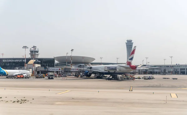 Самолеты различных авиакомпаний находятся рядом с посадочным терминалом международного аэропорта Бен-Гурион, недалеко от Тель-Авива в Израиле — стоковое фото