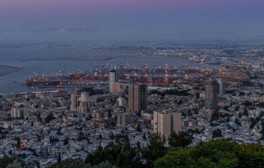 İsrail'de Hayfa şehrinin şehir ve limanına Carmel Dağı'ndan gün batımı manzarası