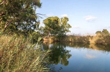 Kuzey İsrail'de Kfar Vitkin yakınlarındaki Alexander Nehri üzerinde batan güneşin ışınlarıpanoramik görünümü