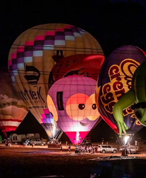 Napompowane i oświetlone balony na gorące powietrze są na ziemi i uczestniczyć w nocnym show na gorącym powietrzu balon festiwalu — Zdjęcie stockowe