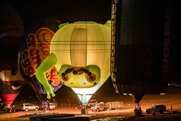 Napompowane i oświetlone balony na gorące powietrze są na ziemi i uczestniczyć w nocnym show na gorącym powietrzu balon festiwalu — Zdjęcie stockowe