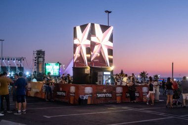 Ziyaretçiler İsrail'in Nahariya şehrinin gezinti bira festivalinde İsrail Goldstar bira şirketinin standı yakınında durmak.