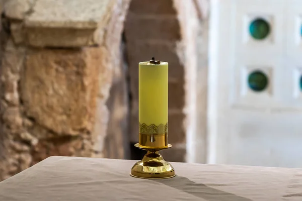 Dekorativní plynová svíčka stojí na stole v postranní kapli v katolickém kostele pro křesťanskou proměnu na hoře Tavor nedaleko Nazaretu v Izraeli. — Stock fotografie