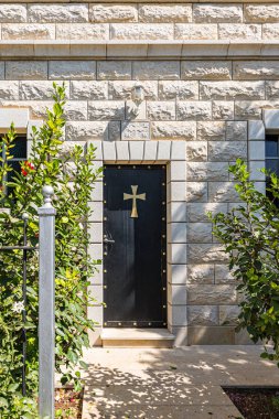 Cross on the door to the residential building in the courtyard of the Greek Orthodox Monastery of the Transfiguration located on Mount Tavor near Nazareth in Israel clipart
