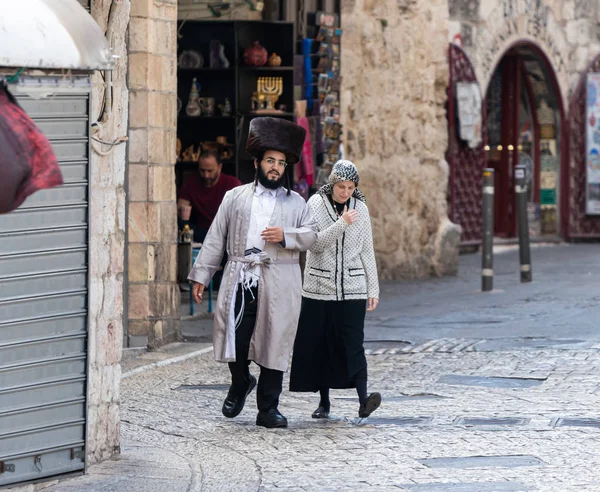 Para religijnych Żydów-mężczyzna i kobieta-spacer po starym mieście i rozmawiać między sobą w Jerozolimie, Izrael — Zdjęcie stockowe