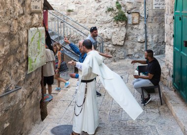A local resident shows a monk on a map how to get there in the Old City in Jerusalem, Israel clipart