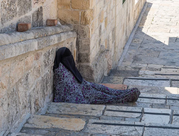 무슬림 여성이 계단에 앉아 이스라엘 예루살렘의 올드 시티에 있는 바위 건물의 돔 근처에서 자선을 요청합니다. — 스톡 사진